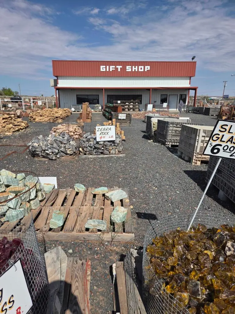 Rock yard with petrified wood and rough stone on pallets in front of the gift shop at Jim Gray's Petrified Wood Co. in Holbrook