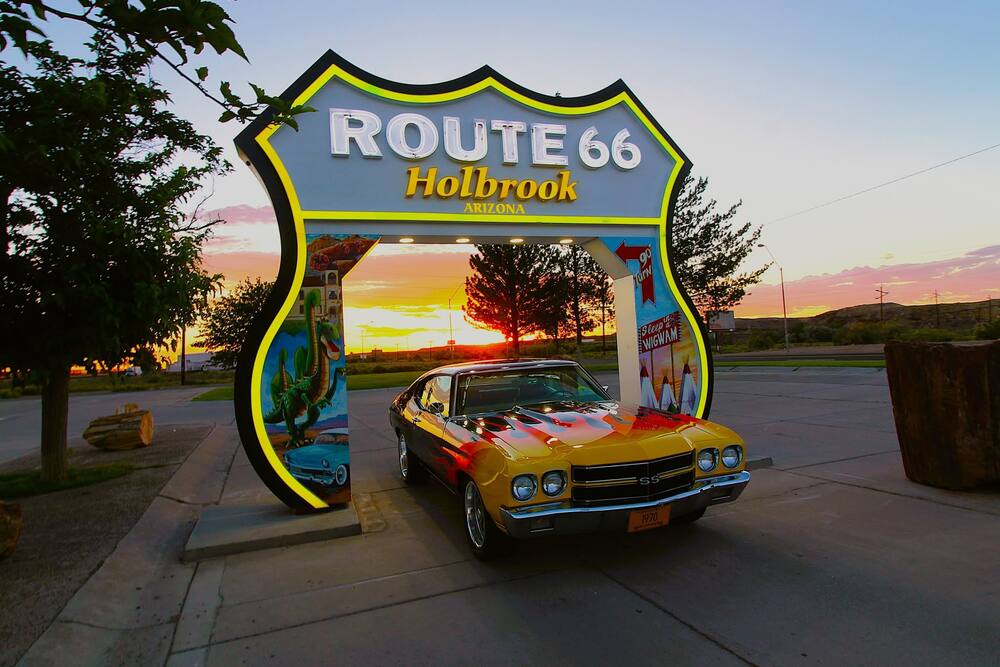 The Route 66 Holbrook arch sign with a classic car