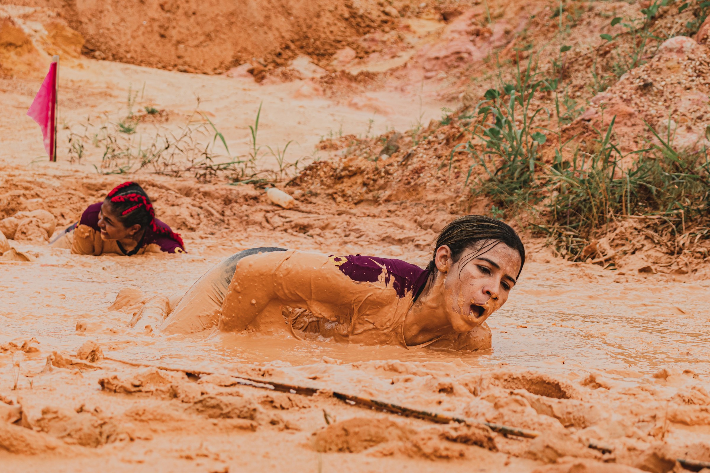 A runner crawling through a mud pit