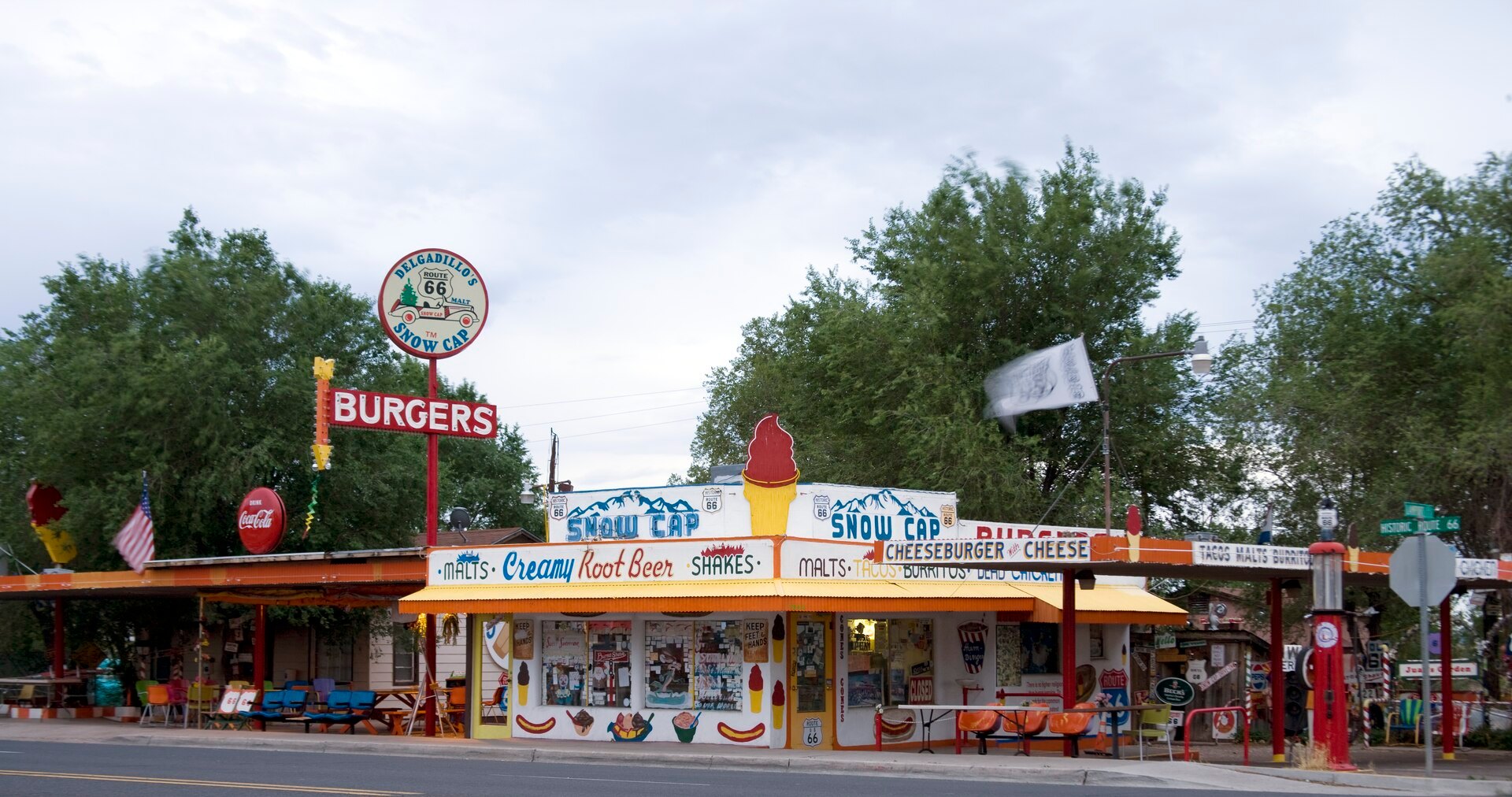 Colorful front of Delgadillo's Snow Cap Drive-In in Seligman with burger and ice cream signs